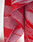 detail von gestricktem tuch in rot und rosa