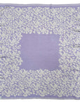 Personalisierte lilimoon Babydecke gestrickt aus Baumwolle mit Kaschmir in Flieder und Cremeweiss mit Blütenmuster.