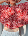 gestricktes cape getragen von einer frau in rot und weiß mit feinem blättermuster