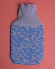 gestrickter wärmflaschenbezug in hellgrau und hellblau mit blütenmotiv