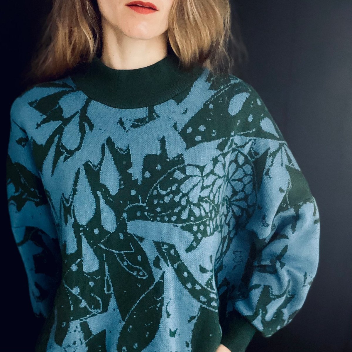 gestrickter pullover in moosgruen und blau getragen von einer Frau