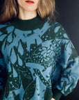 gestrickter pullover in moosgruen und blau getragen von einer Frau